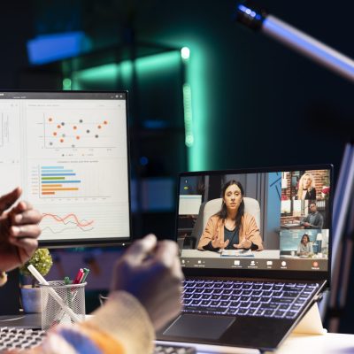 Black man using laptop to participate in online meetings Waving from his apartment, black man using laptop to participate in online meetings. Male freelancer uses wireless technology for video conferencing with colleagues to discuss work remotely.